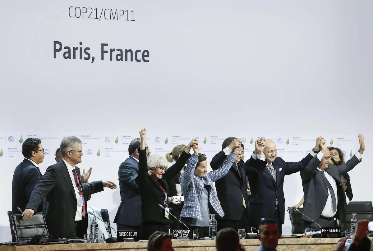 French president Francois Hollande, COP21 president Laurent Fabius, UN secretary-general Ban-Ki-Moon and UN Climate Change’s Christiana Figueres celebrate the adoption of the Paris Agreement, 2015