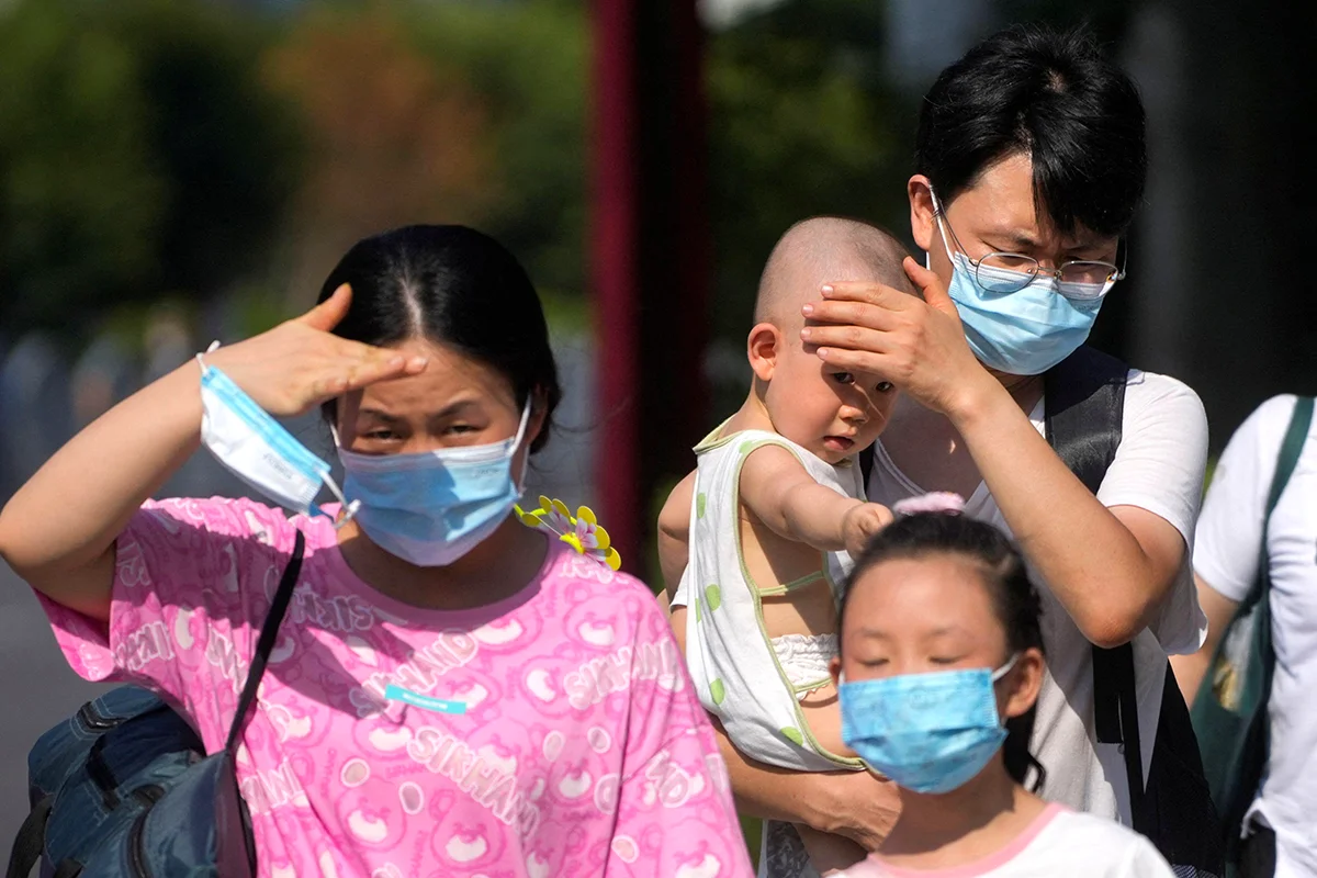 People move about in Shanghai, China, as a red alert is declared due to high temperatures on 23 July 2022.