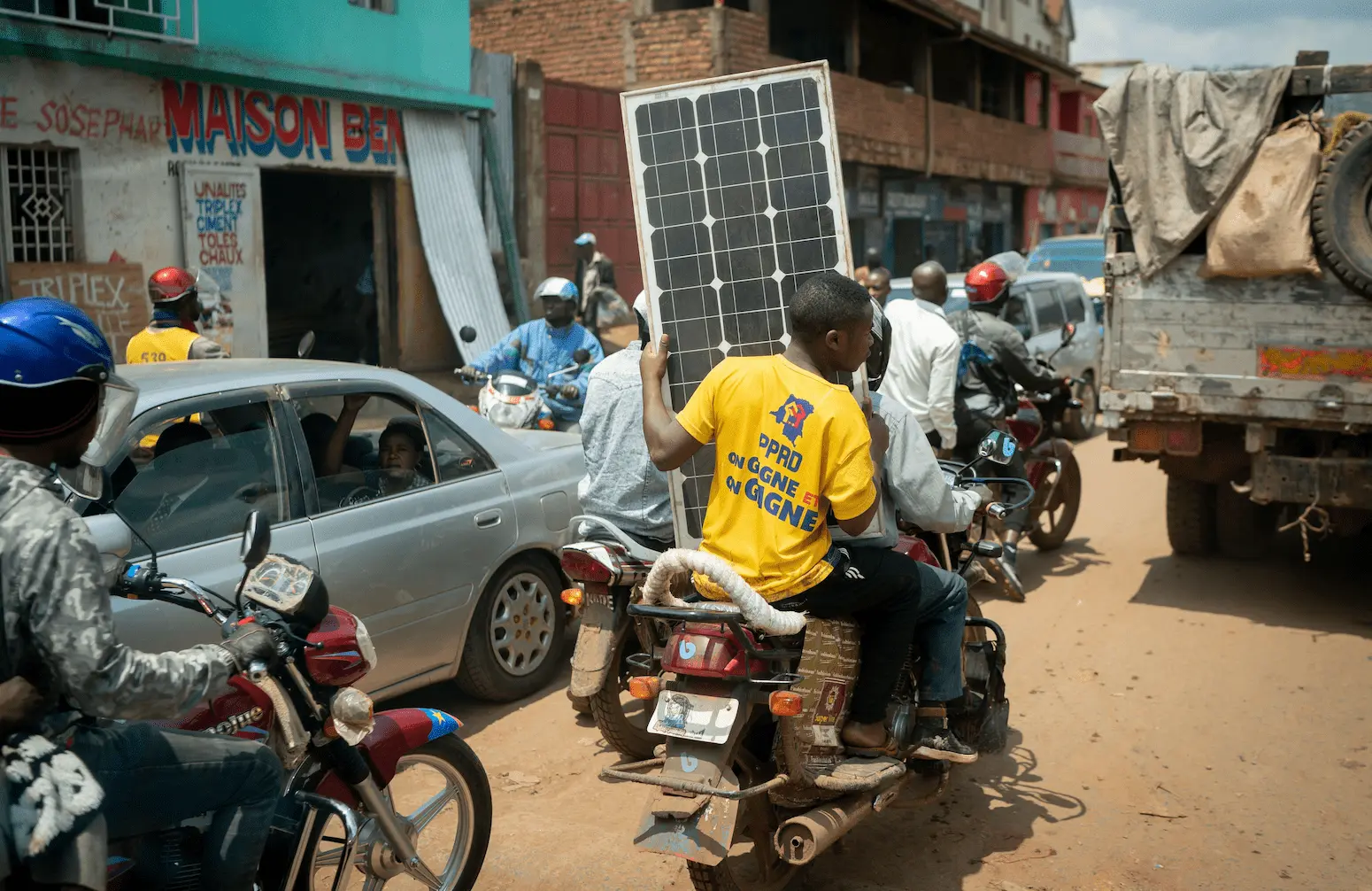 A motorcyclist transports a solar panel in dense traffic in the megacity of Bukavu in Eastern Congo