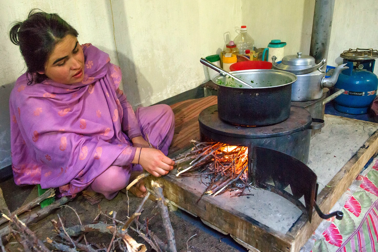 A woman cooks on a fire inside her house in Gilgit-Baltistan, Pakistan.